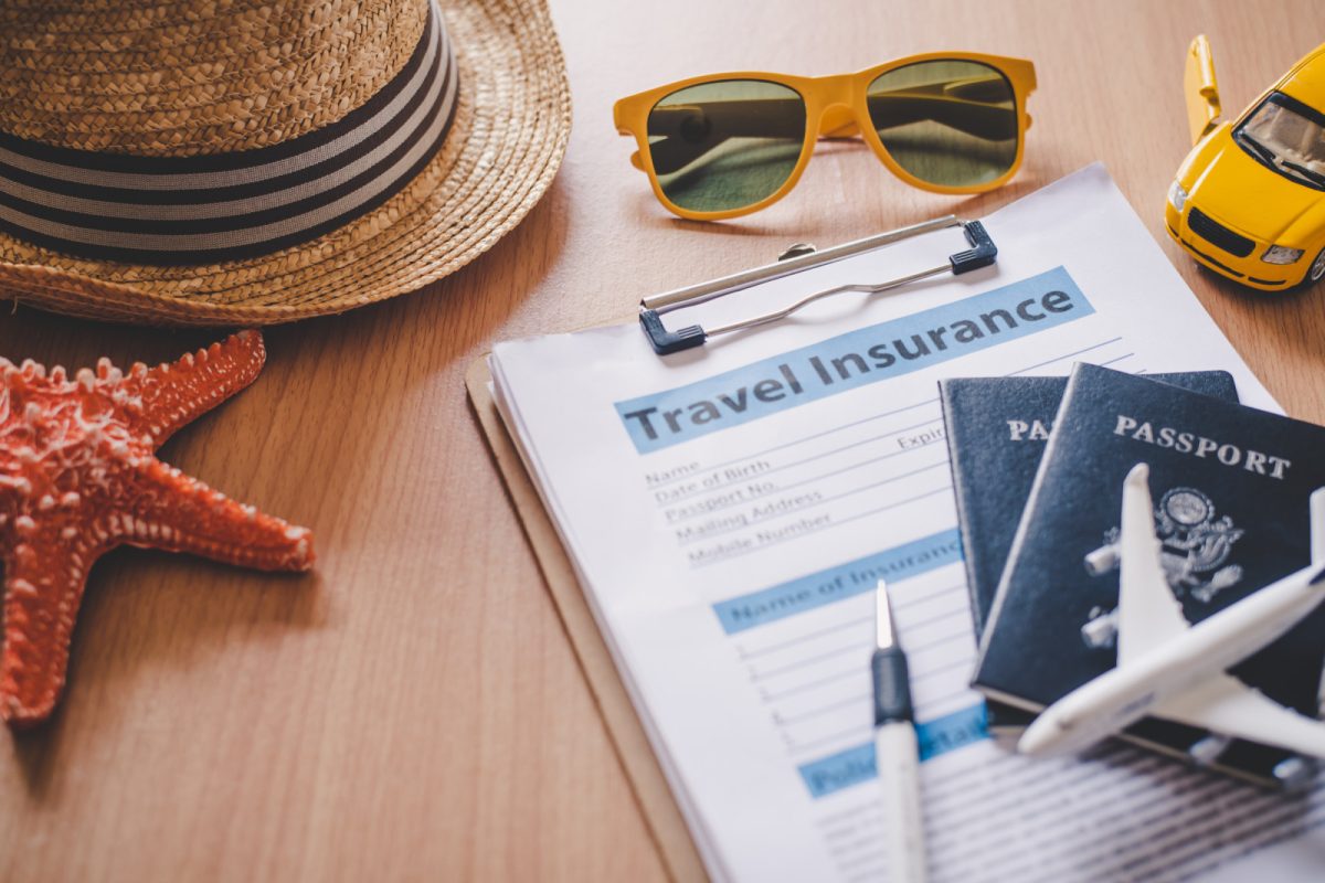 Travel insurance form with passports and other travel essentials