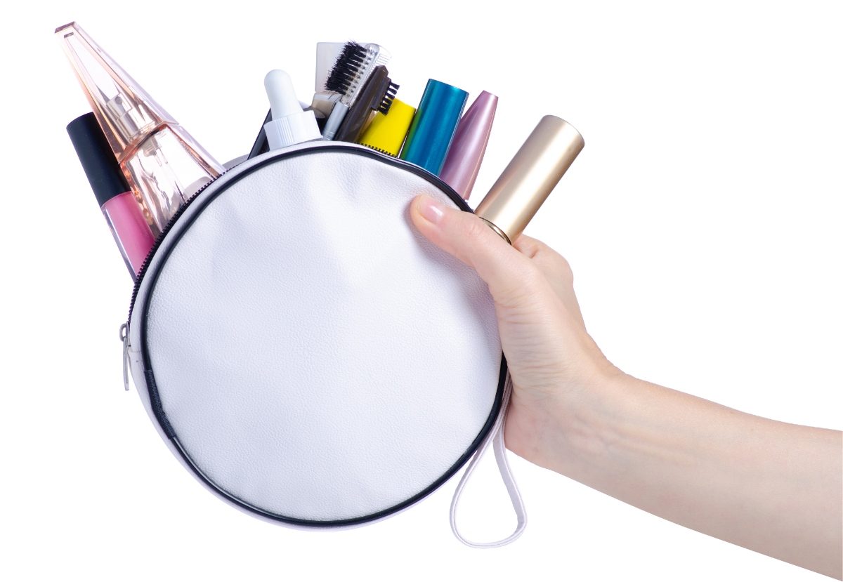 Close-up of a hand holing a a pouch filled with a travel makeup kit