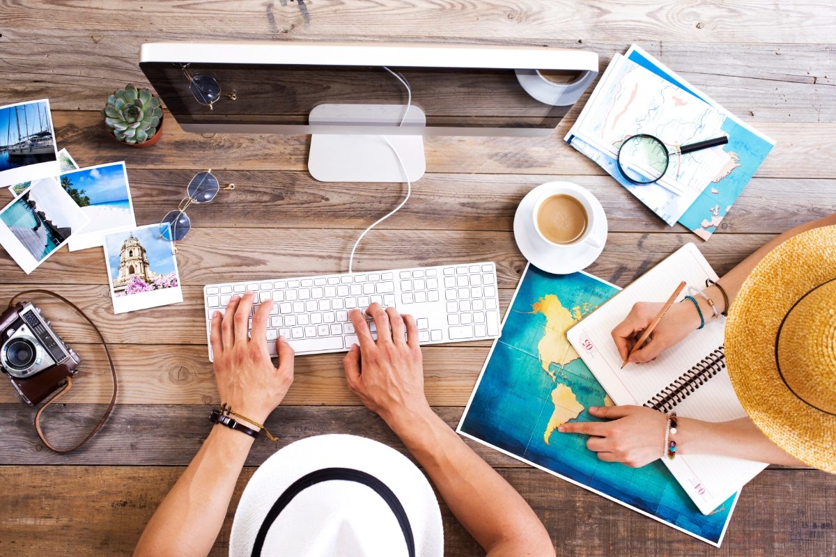 Two people brainstorming and travel planning on a computer