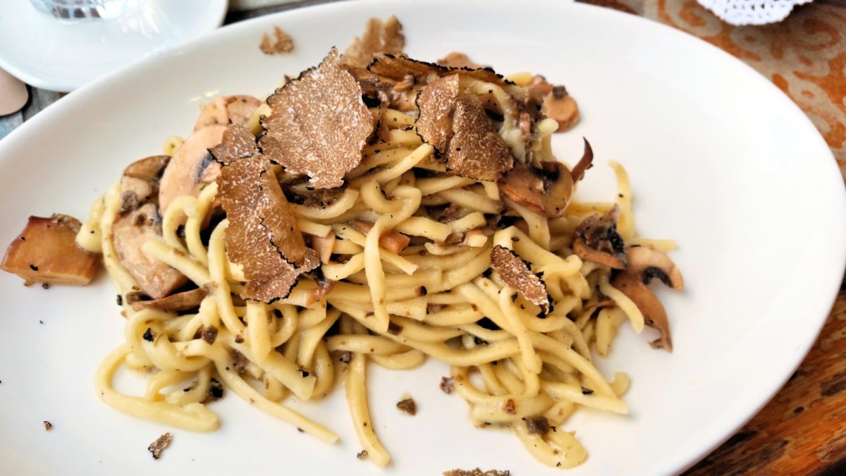 Italian pasta with shaved truffle served on a white plate