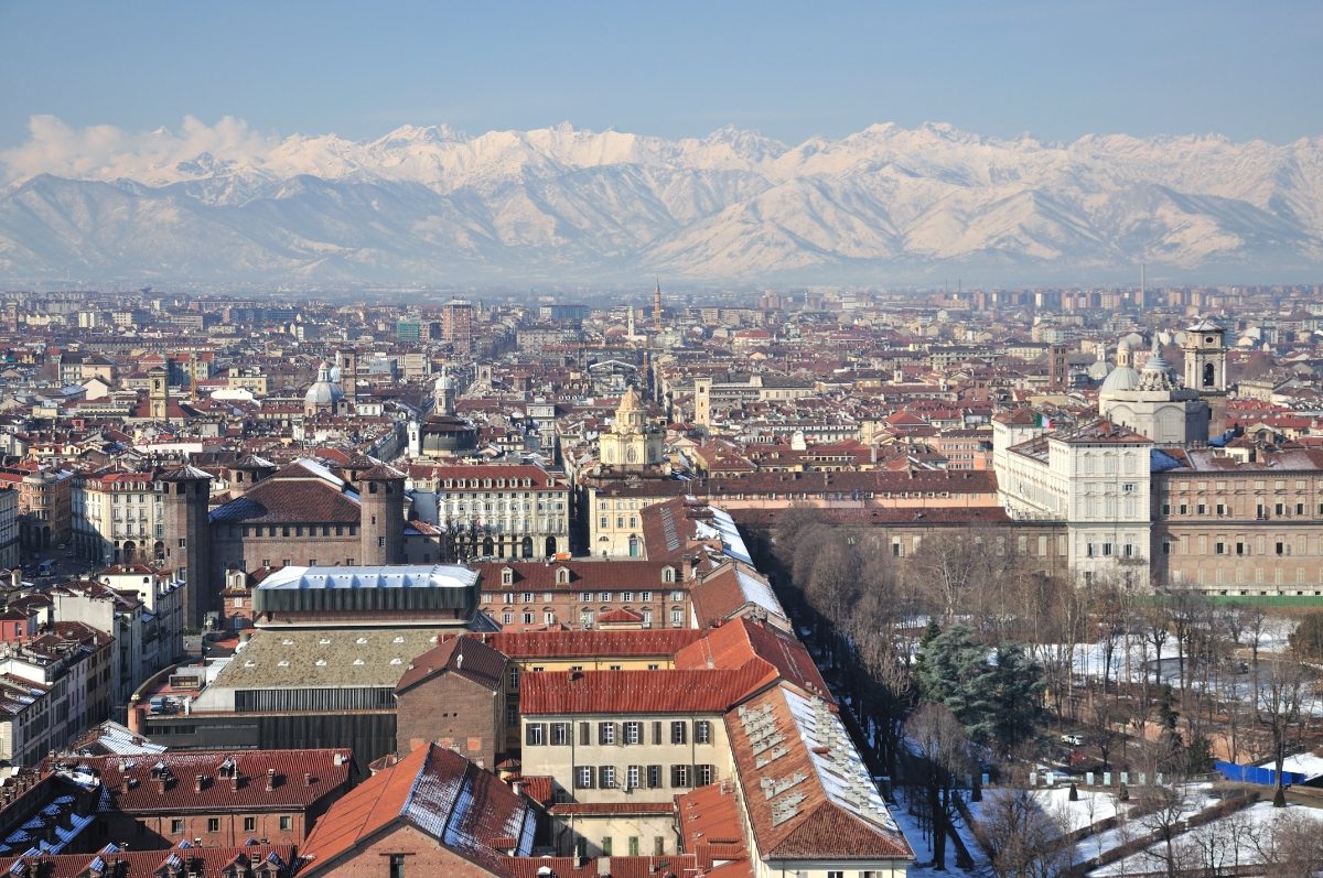 Aerial view of Turin, Italy, with a mountain range in the background during winter