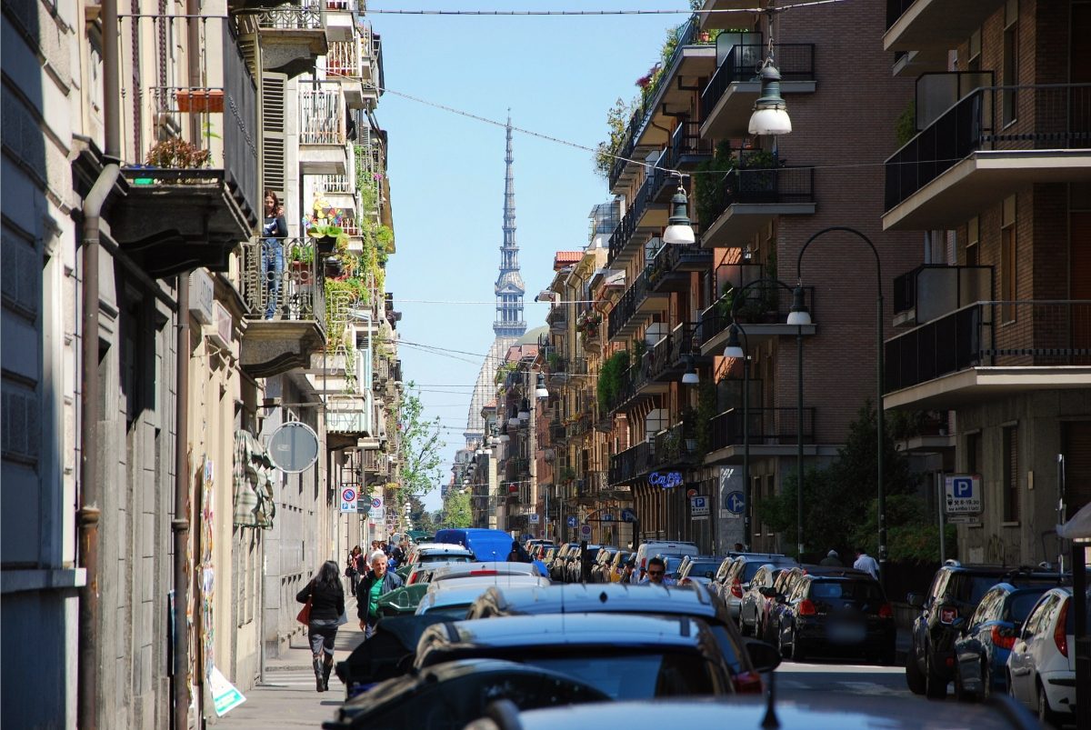 Street in Turin, Italy with parked cars and the Mole Antonelliana in the background