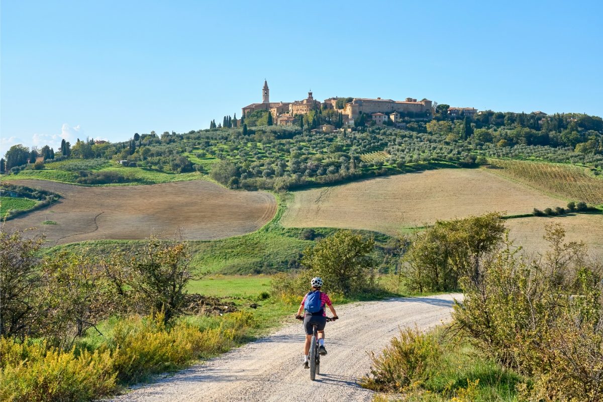 Woman biking and exploring the Ghianti area of Pienza  in Tuscany, Italy