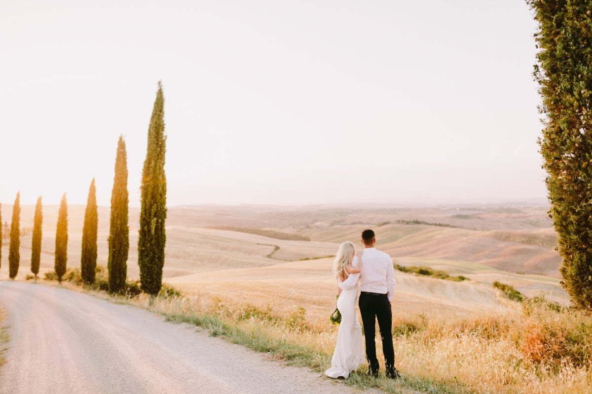 Bride and groom looking at the panoramic view of Tuscany, Italy