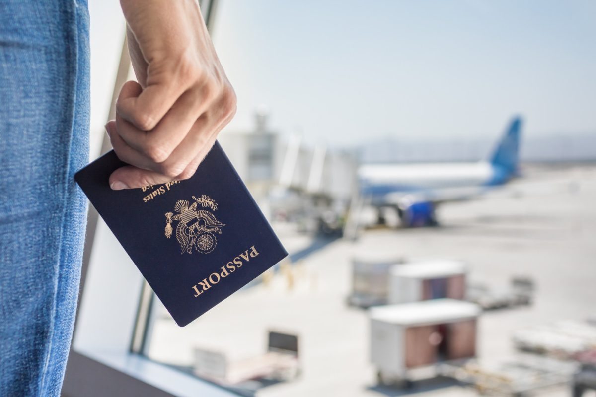 Close-up of a hand holding a passport at airport