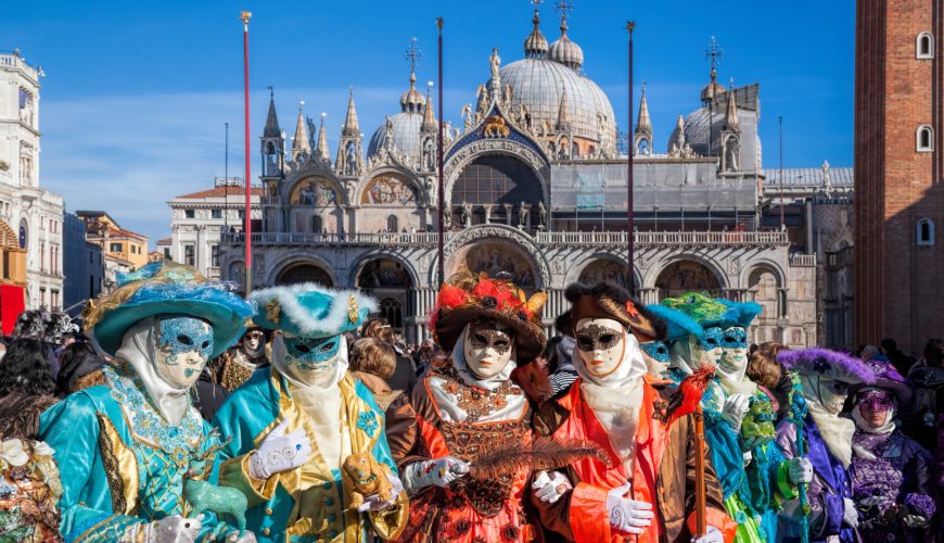 Group wearing colorful costumes and masks during the Venice Carnival Festival in Venice, Italy