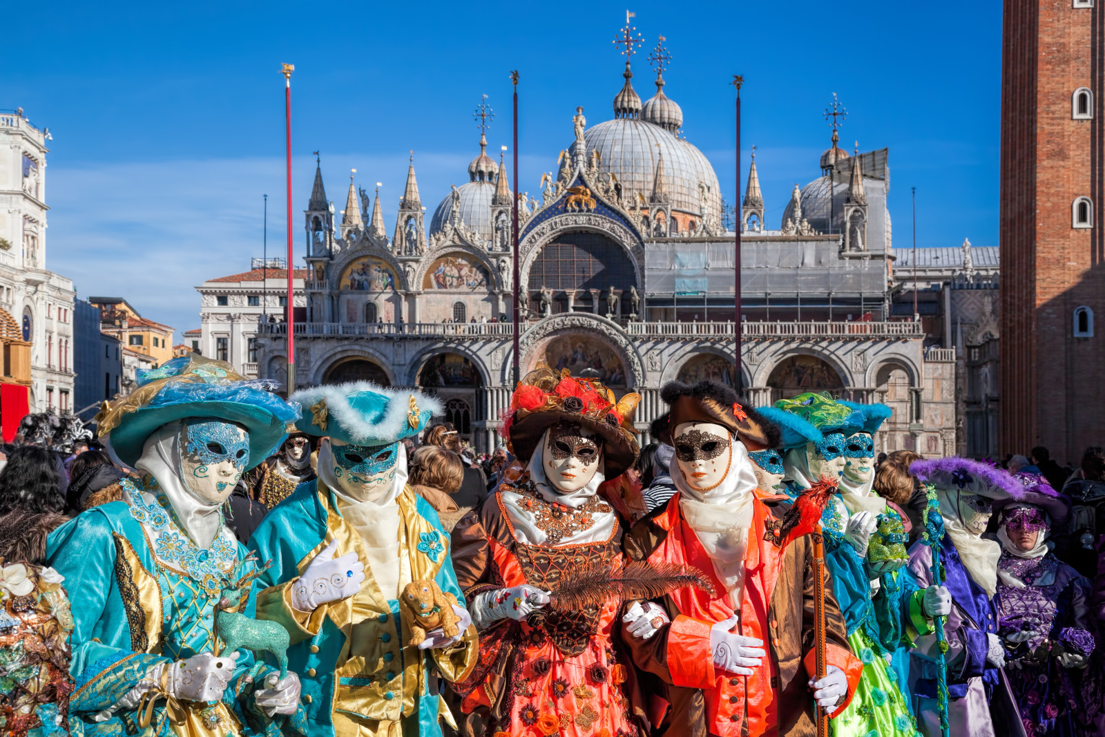 Group wearing colorful costumes and masks during the Venice Carnival Festival in Venice, Italy