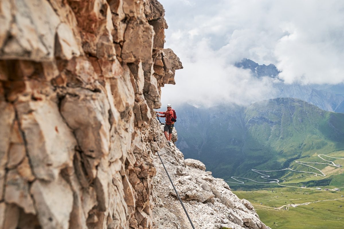 Man climbing and exploring the Via Ferrata Cesare Piazzetta Pordoi Pass in the Dolomites, Italy