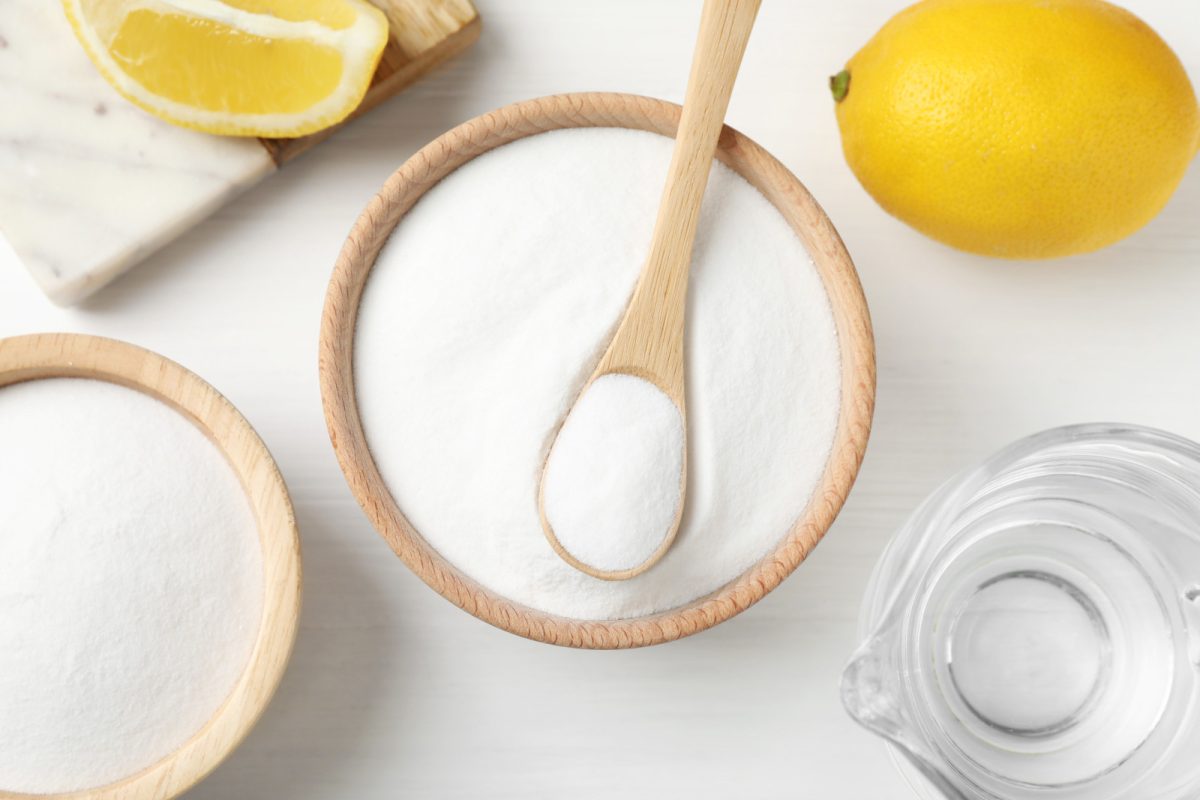 Top view of a vinegar and baking Soda and lemons on the side