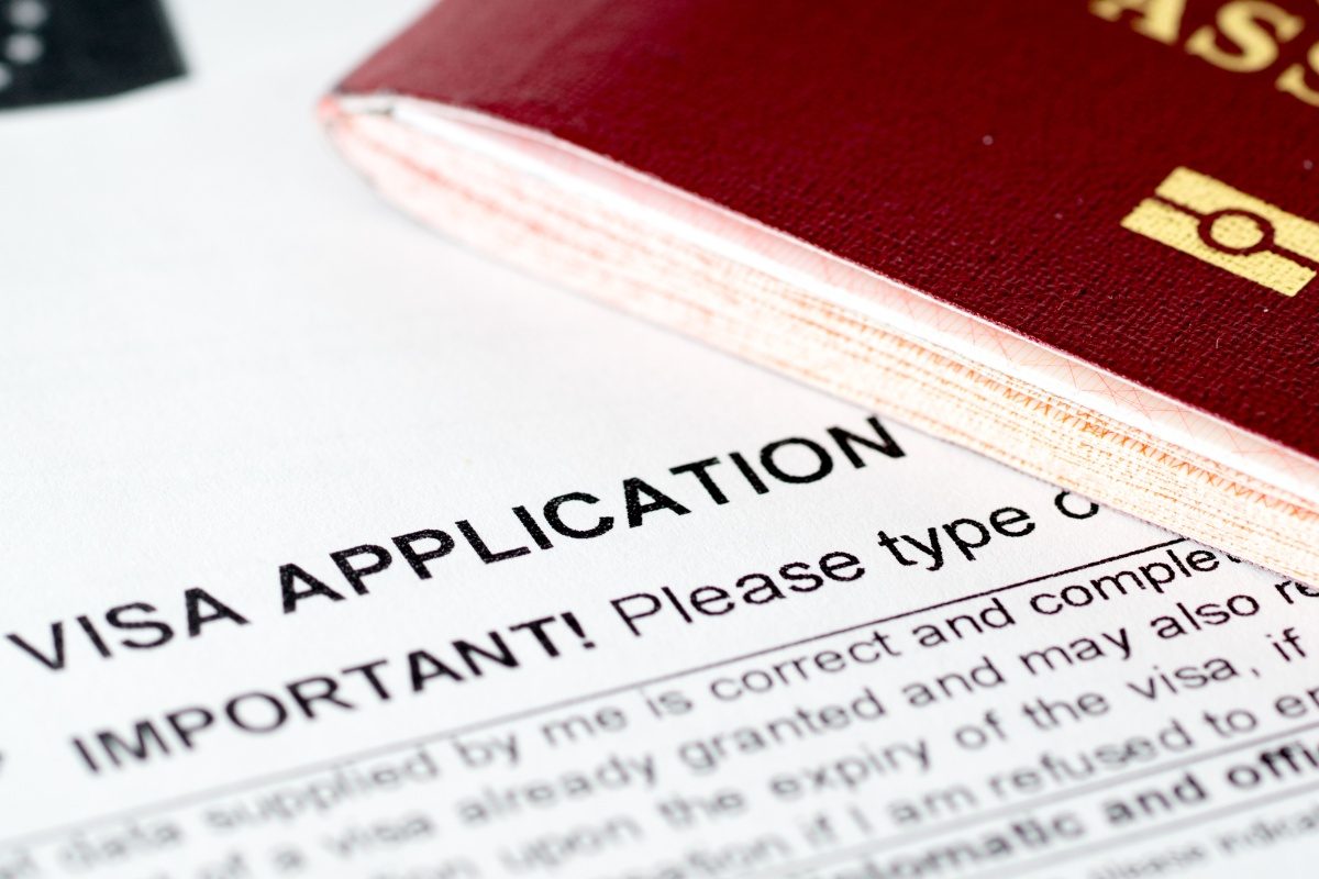 Close-up of a visa application document next to a passport