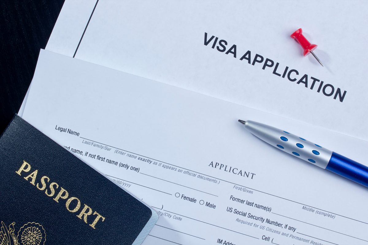 Close-up of the Visa application form with pen and passport on the side