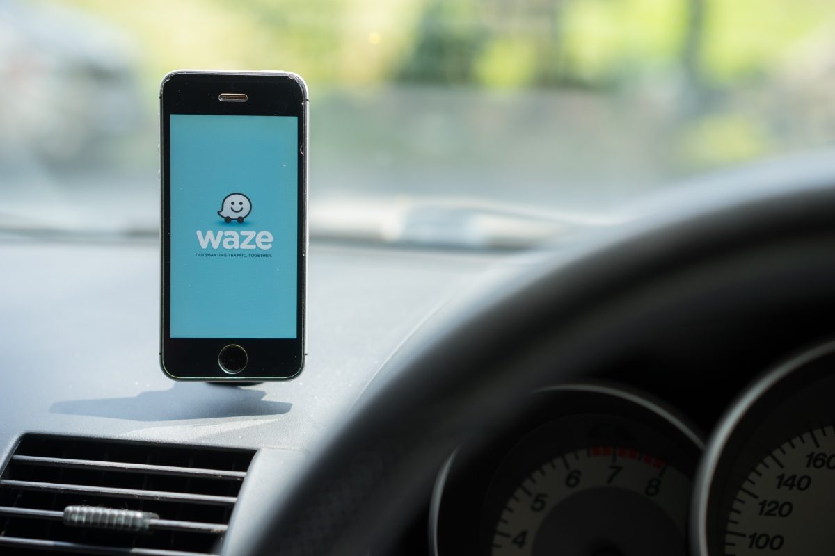 Close-up of a phone inside a car showing the Waze GPS Map App logo