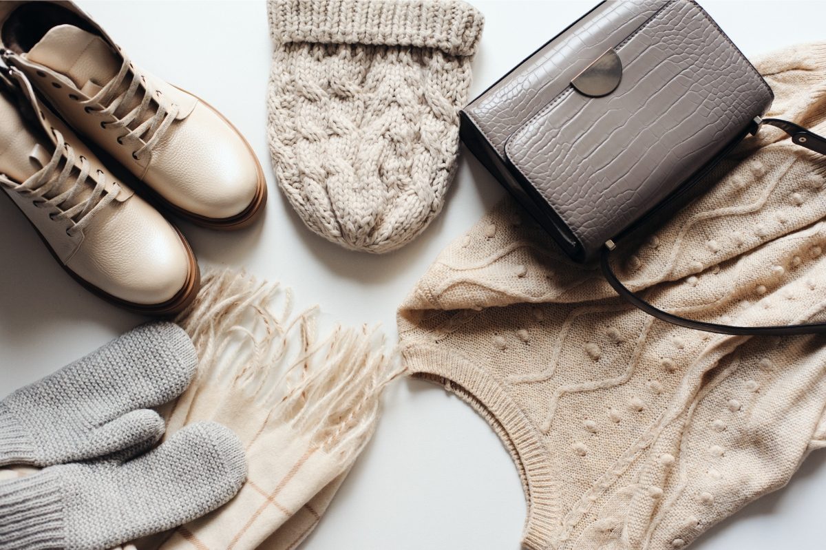 Top view of winter fashion clothes and accessories: a hat, mittens, and a scarf