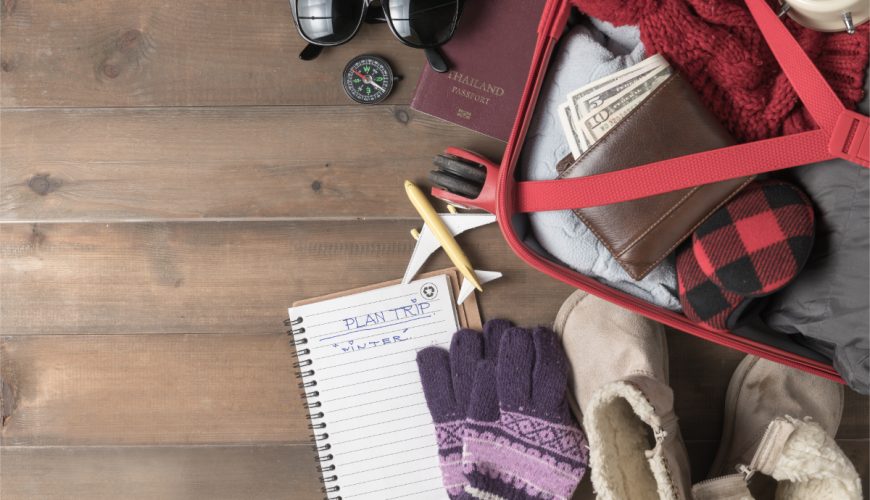 Close-up of luggage packed with winter clothes and accessories for a winter trip