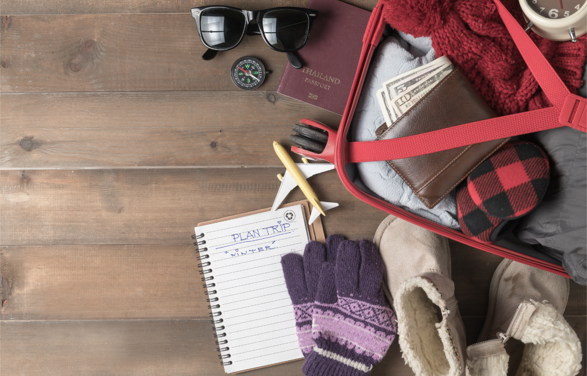 Close-up of luggage packed with winter clothes and accessories for a winter trip