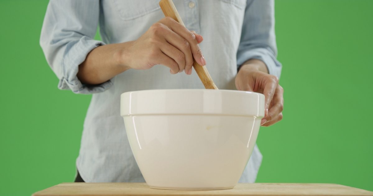 Woman mixing food in a big white bowl